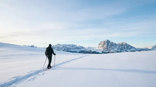 Escursionisti con ciaspole in paesaggio montano innevato italiano con vista sulle Alpi