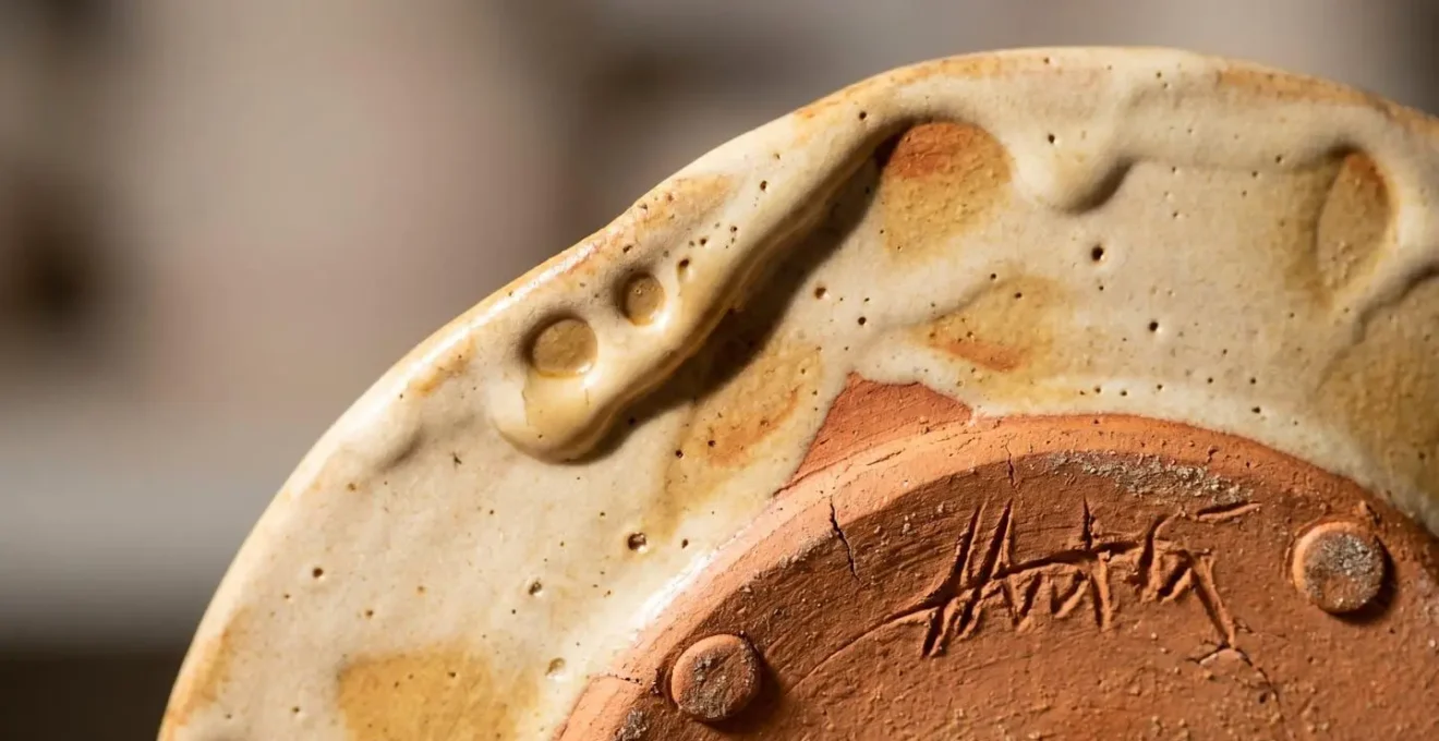 Dettaglio macro della superficie e del fondo di una ceramica artigianale italiana con segni di lavorazione manuale