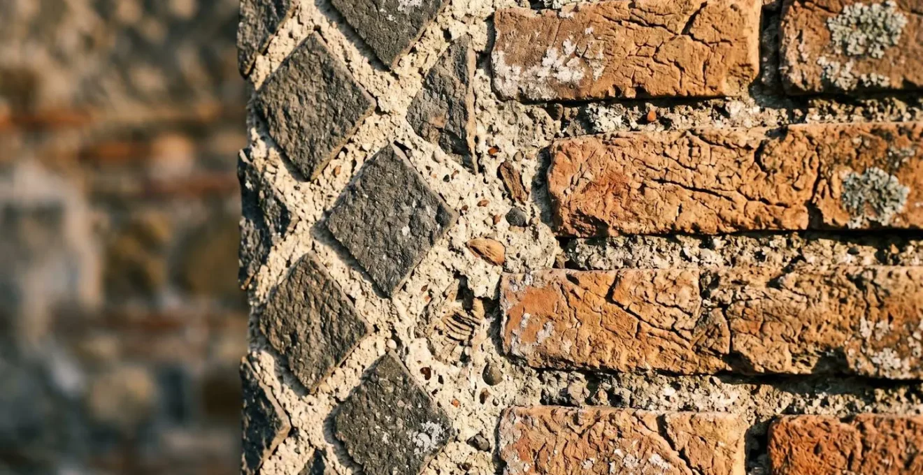 Dettaglio ravvicinato di una sezione muraria romana che mostra diverse tecniche costruttive stratificate nel tempo